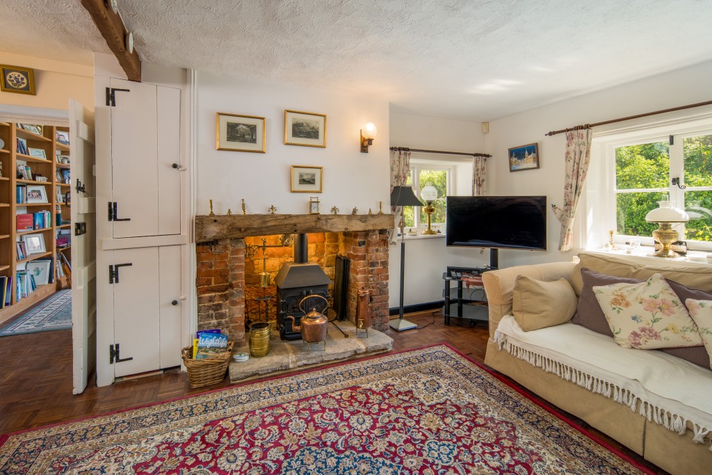 Lot: 108 - CHARMING COTTAGE WITH SELF-CONTAINED ANNEXE, GARDENS AND GARAGE - Living room with fireplace